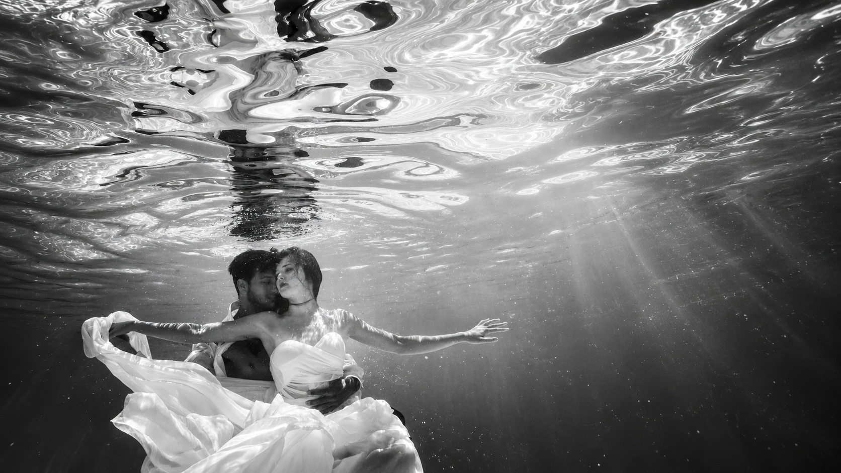 Black and white underwater portrait of a bride and groom, photographed by Shimmy Lautman